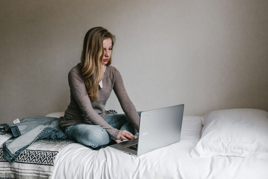 girl with laptop on her bed