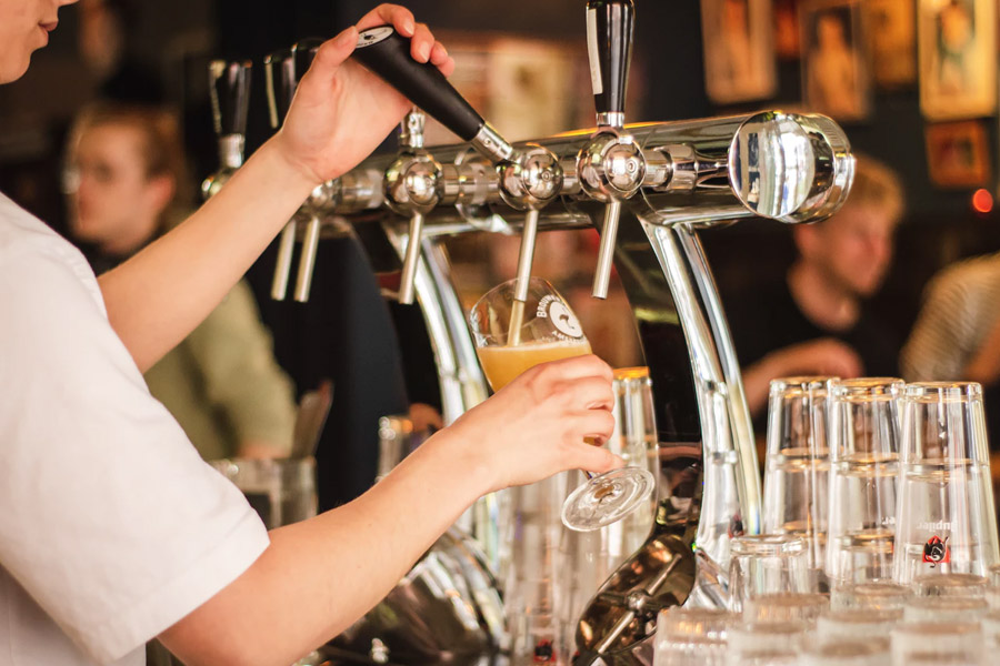 Man pulling a pint at a bar