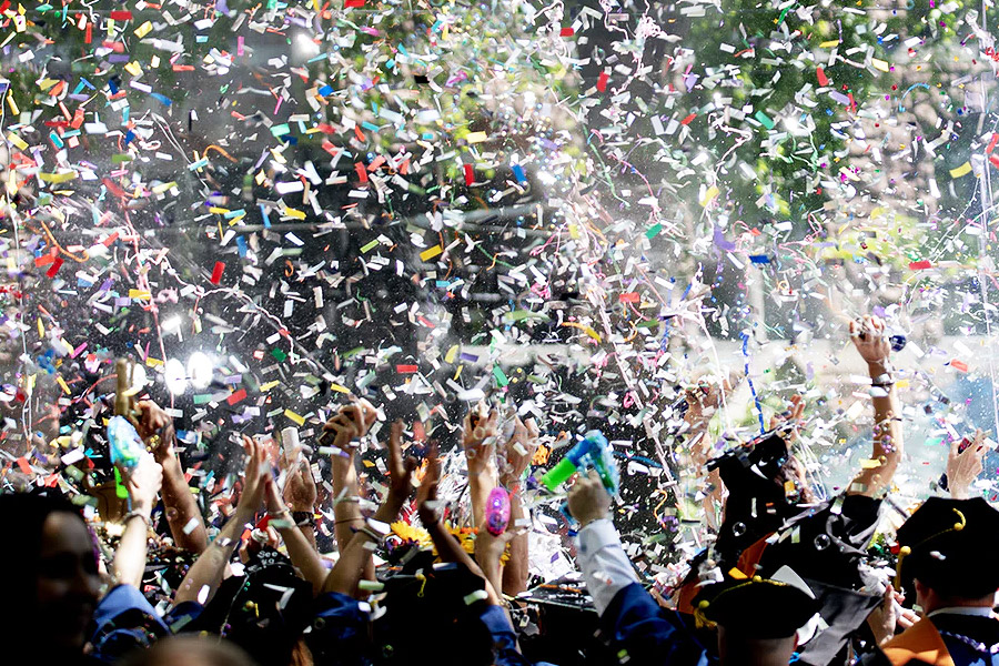 group of graduated students celebrating with confetti falling