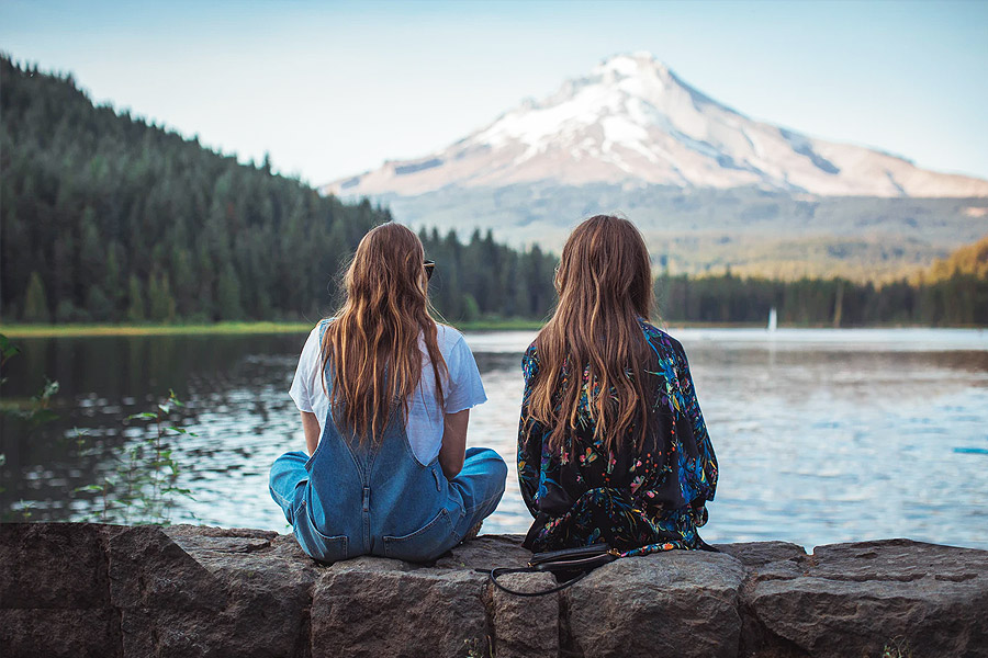 two friends sat together in a mountain scene