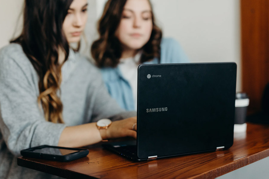 Two female students looking at a laptop