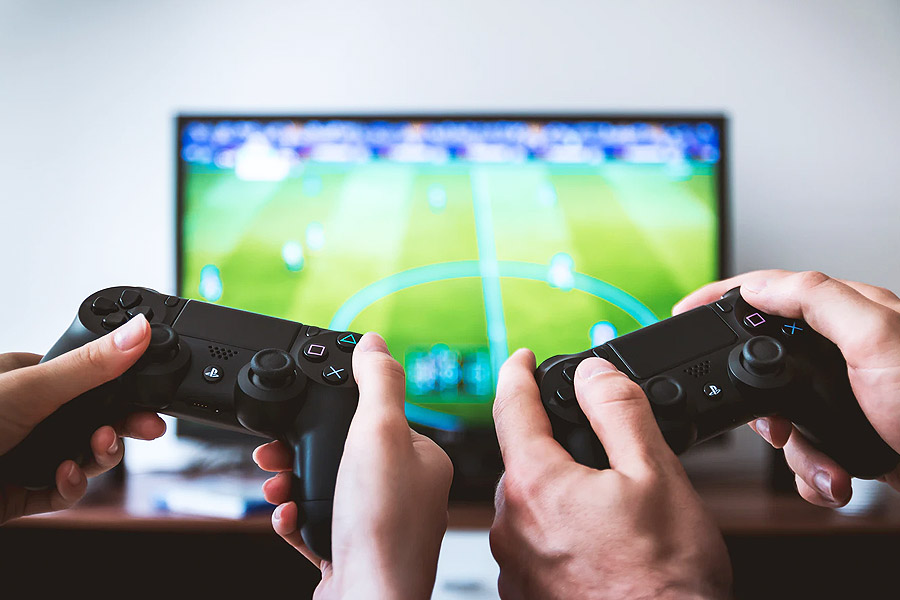 two game controllers with TV in the background playing a football game