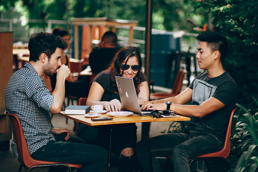 group of friends with laptop studying in a cafe