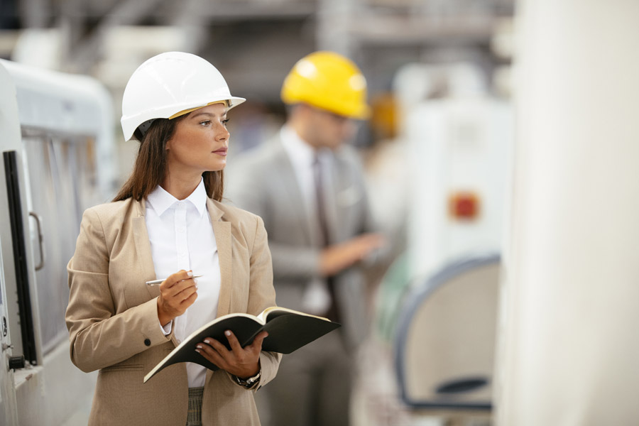 woman in a suit and hardhat holding a clipboard